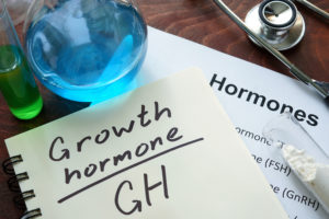 growth hormone written on notebook. Test tubes and hormones list
